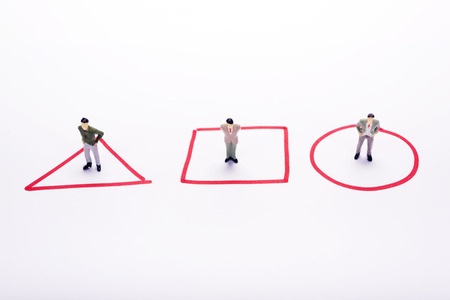 Miniature people three business men standing in red diagrams over white background or backdrop.の写真素材