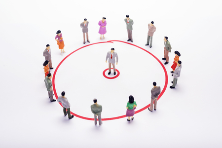 Miniature business people circle scheme over white backdrop or background.