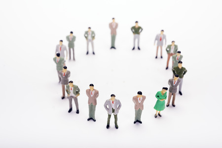 Miniature business people standing in circle over backdrop or background.の写真素材