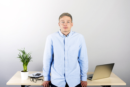 Office man standing by desk smillingの写真素材