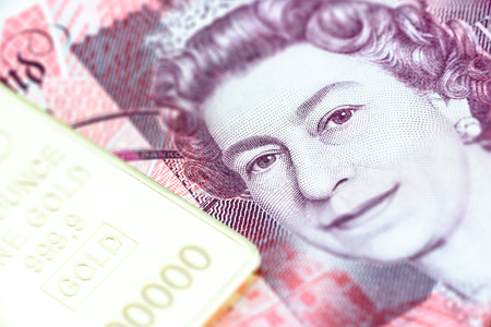 Great Britain fifty pounds notes, a macro close-up with gold bullion.