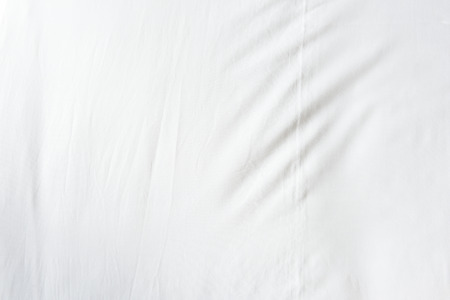 Top view of wrinkles on an unmade bed sheet after a long night sleep and waking up in the morning.の写真素材
