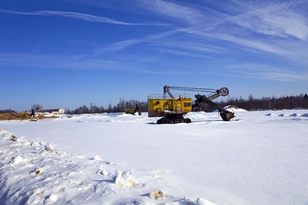Abandoned tractor in winter fieldの写真素材