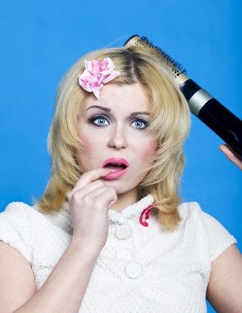 Young blond with hairdryer studio shot pin-up styleの写真素材