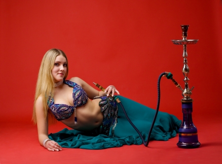 beauty young woman with hookah on redの写真素材