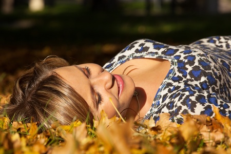 woman lay on ground in autumn leavesの写真素材