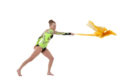 Young beauty gymnast fight with flying fabric isolatedの写真素材