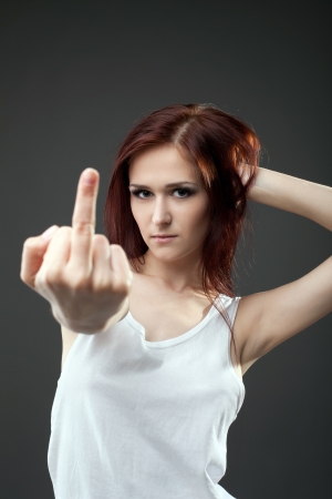 Anger young woman in tank top with fuck sign expressive portraitの写真素材