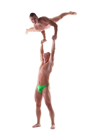 Two young strong man show gymnastic performance isolatedの写真素材