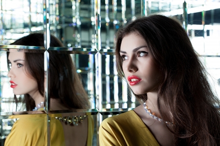 Portrait of beautiful brunette woman near mirrorの写真素材