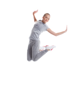 Image of smiling sporty girl jumping in studio, isolated on white backgroundの写真素材