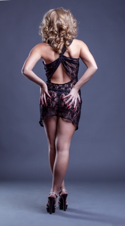 Charming slender woman posing in erotic negligee back to cameraの写真素材