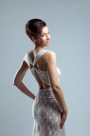 Portrait of slyly smiling girl posing in erotic lacy dressの写真素材