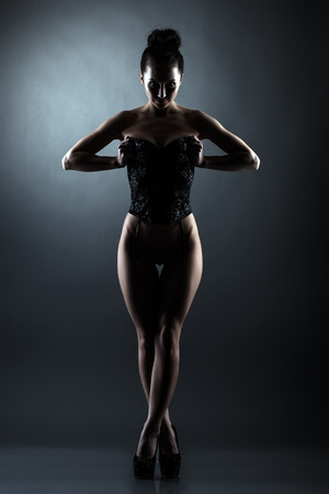Hot confident woman posing in erotic lingerie, on dark gray backgroundの写真素材