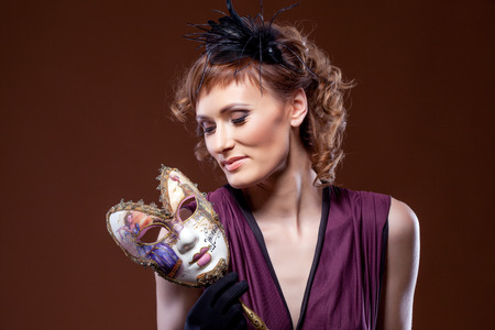 Pretty middle aged woman holding mask. Concept of Two-Face