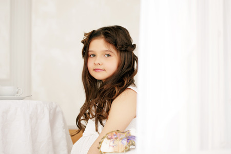 Portrait of cute brown-eyed girl with long curly hairの写真素材