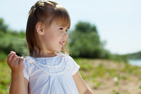 Portrait of cheerful little girl posing in parkの写真素材
