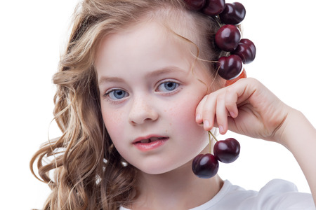 Portrait of adorable freckled girl with cherriesの写真素材