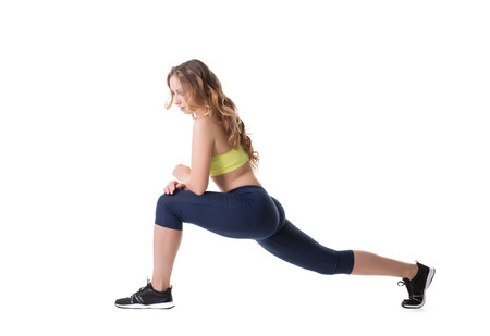 Studio shot of active girl warming up, isolated on white