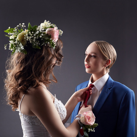 Gay wedding. Pretty bride straightens grooms tieの写真素材