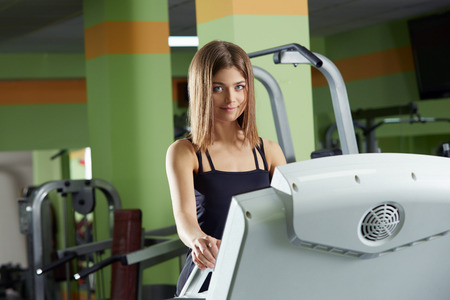 Lovely young woman posing at camera while training in gym