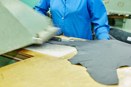 Image of cutting leather using semiautomatic press in workshopの写真素材