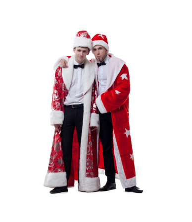 Funny friends posing in coats of Santa Claus, isolated on whiteの写真素材