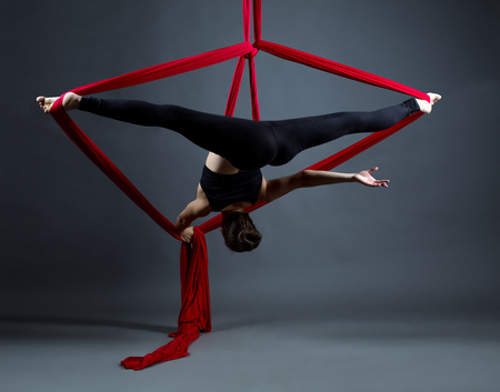 Studio photo of acrobat performs on hanging ribbonsの写真素材