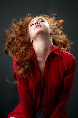 Sexy redhead model posing waving her beautiful hairの写真素材