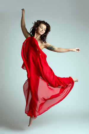 Graceful female dancer posing in jump. Studio photoの写真素材