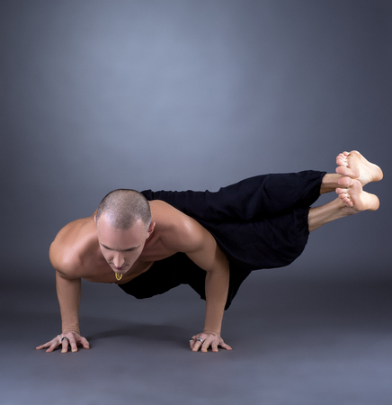 Studio photo of middle-aged man practicing yoga at cameraの写真素材
