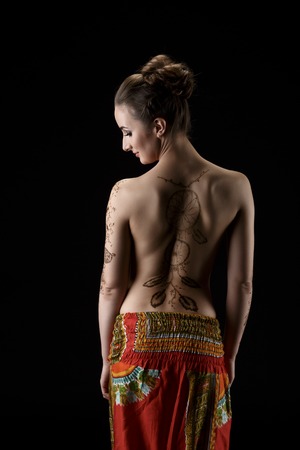 Mehendi. On woman's back henna pattern dreamcatcher. Studio photoの写真素材