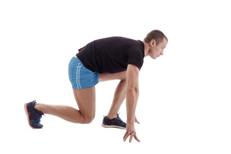 Side view of runner on starting block. Studio photo