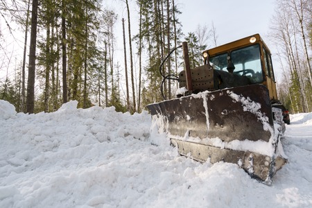 Image of snowblower clears road in forest. Russia