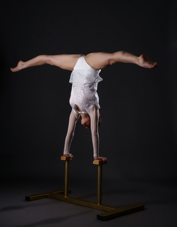 Image of charming gymnast doing handstand on circus standsの写真素材