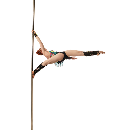 Dance. Pretty female gymnast performs trick on pylon