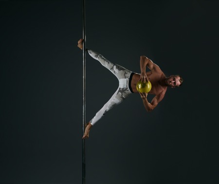 Image of strong man performs complicated trick on pylon