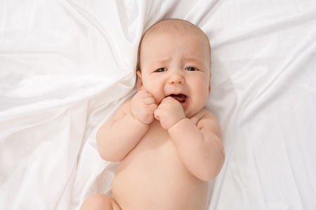 Top view of child crying while looking at camera