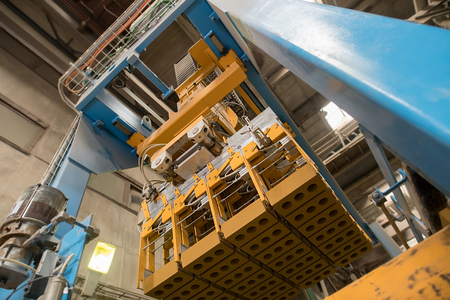 Brickyard. Bottom view of production machine with bricks