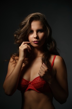 Erotica. Sexy young woman in red bra looking at cameraの写真素材
