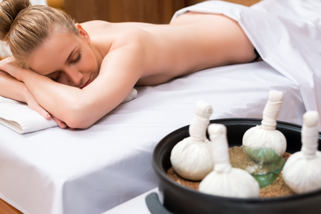 Traditional Thai massage with salt bags. Girl posing lyingの写真素材