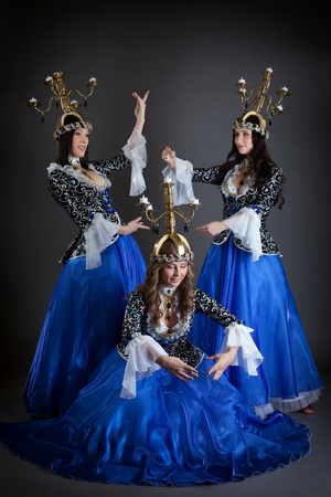 Trio of oriental dancers with candelabras posing in studioの写真素材