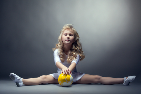 Fascinating little female gymnast posing on splitの写真素材