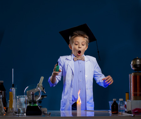 Very surprised boy conducting experiment in laboratoryの写真素材