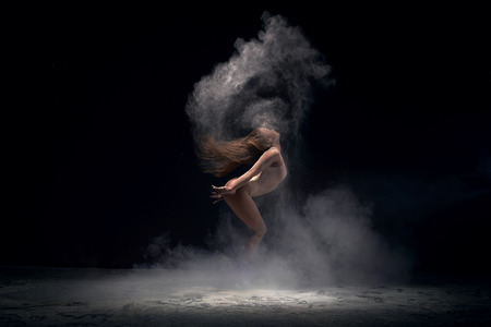 Dancer in motion in cloud of powder, studio shotの写真素材