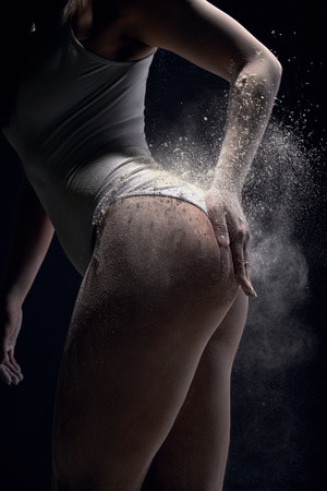 Sporty woman coating her body  with powder chalkの写真素材