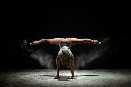 Graceful girl dancing in white dust color