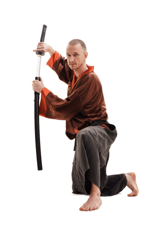 Man in traditional chinese in studio with a swordの写真素材