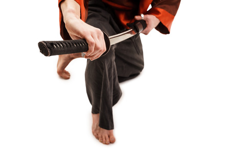 Man in traditional chinese in studio with a sword