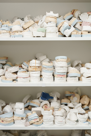 Piles of dentures on several shelves close up shotの写真素材